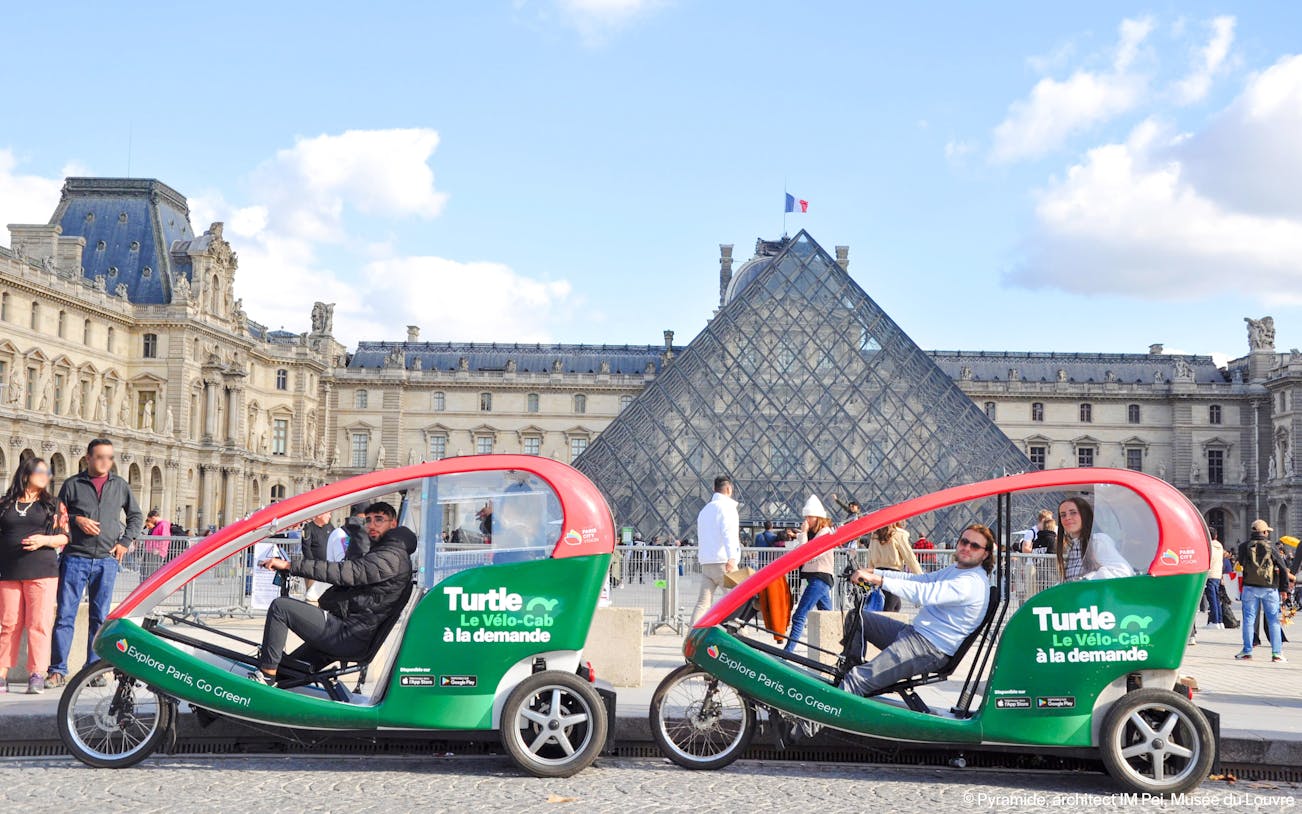 Turtle transport vehicles in front of the Louvre Pyramid, Paris.