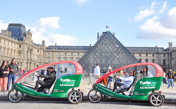 Turtle transport vehicles in front of the Louvre Pyramid, Paris.