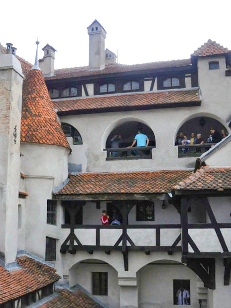 Bran Castle courtyard with visitors exploring historic architecture.