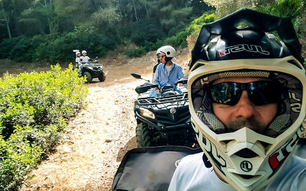 Group on quad bikes exploring forest trail in Alghero.