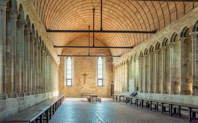 Interior arches and stone columns of Mont Saint Michel Abbey in France.