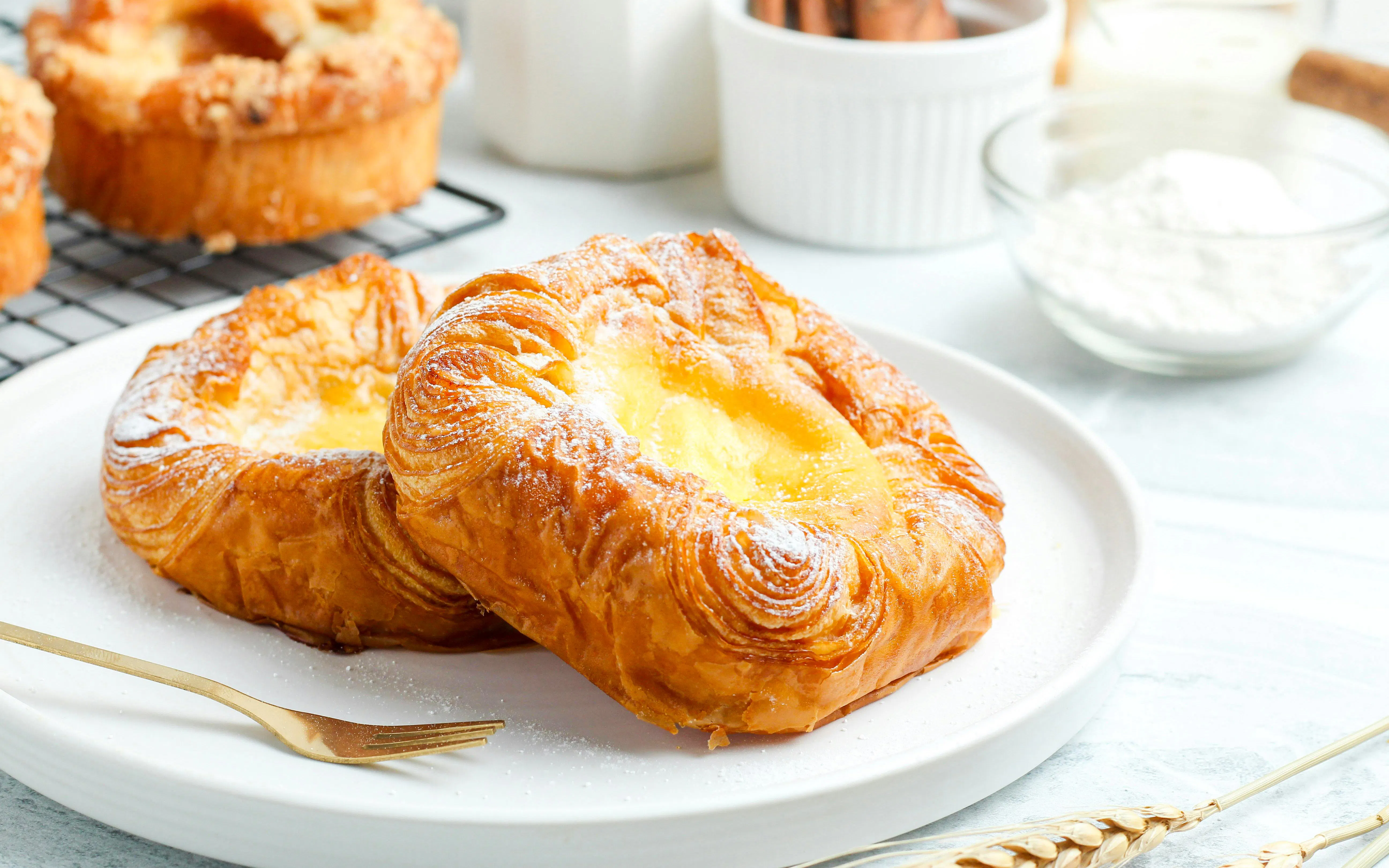 Danish pastry with icing sugar on a white plate.