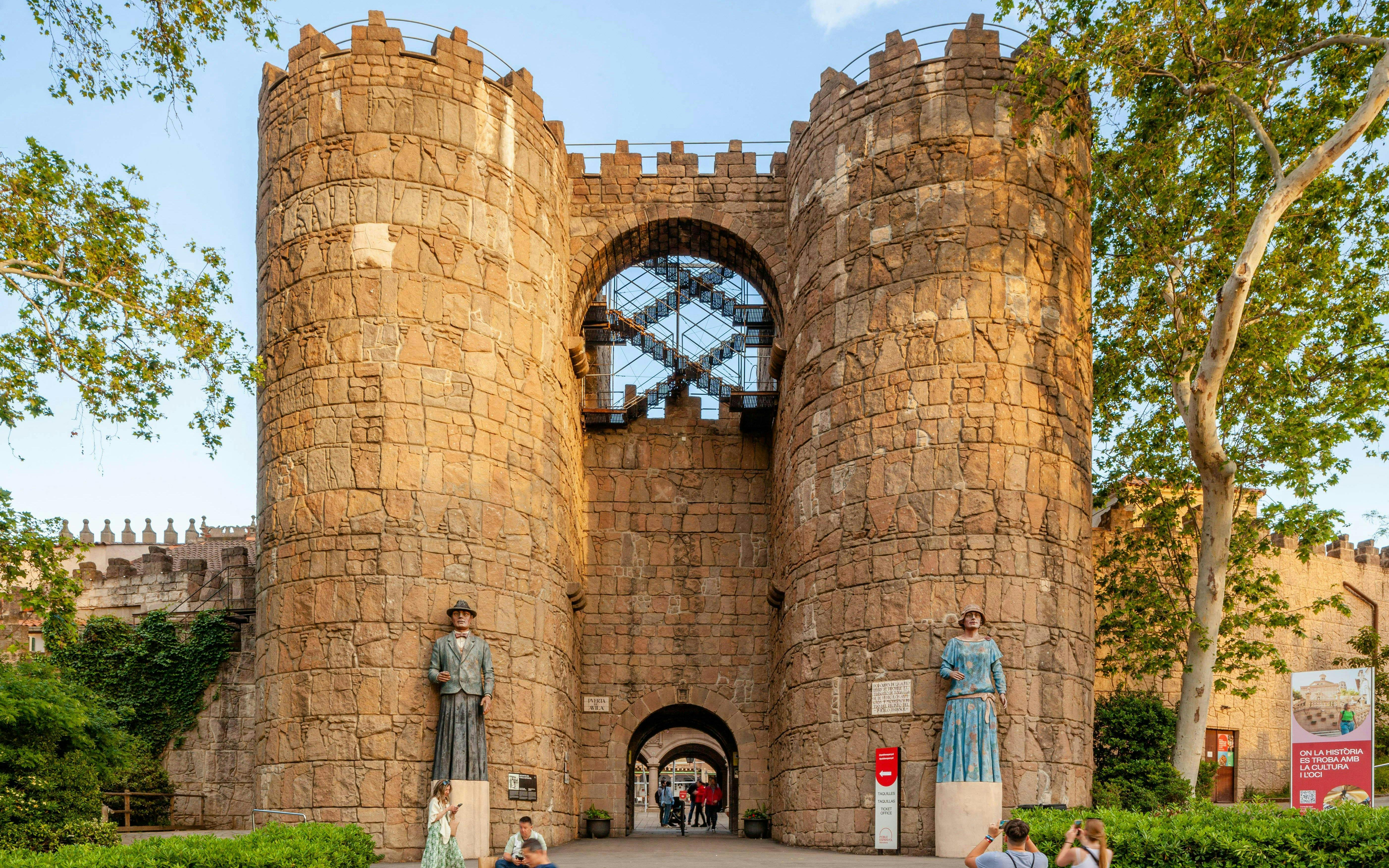 Entrance to Poble Espanyol with stone towers and statues in Barcelona, Spain.
