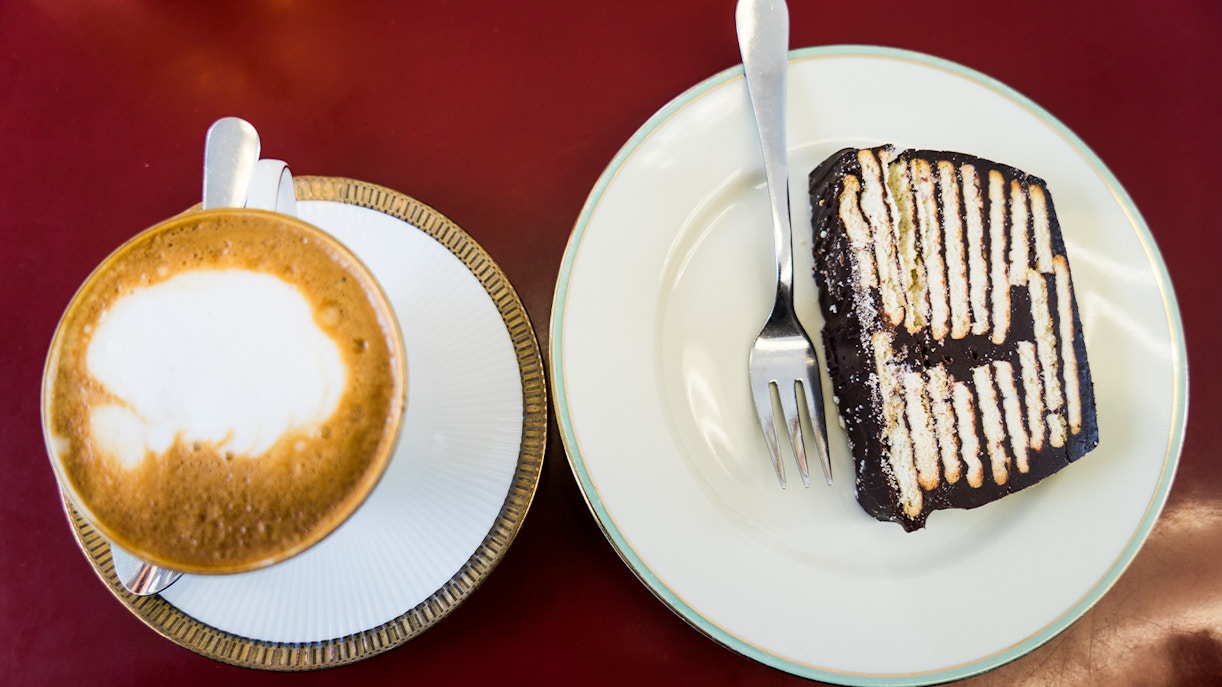 Cafe table with coffee cup and slice of cake.