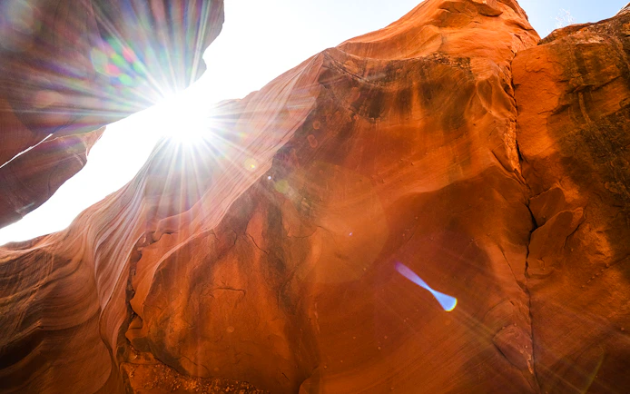 Sunlight streaming through rock formations in Waterhole Canyon.