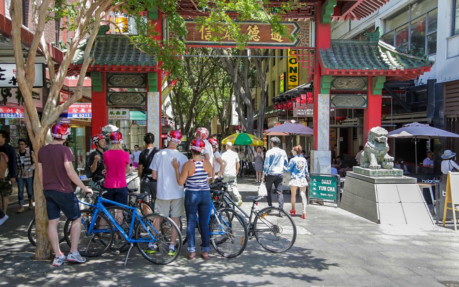 Cyclists on Bonza Bike Tours exploring Chinatown entrance in Sydney.