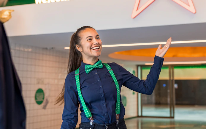 Guide welcoming visitors at Heineken Experience in Amsterdam.