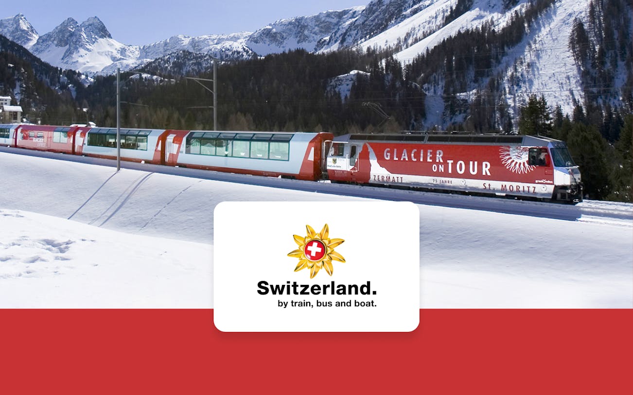 Glacier Express train traveling through snowy Swiss Alps between Zermatt and Chur.