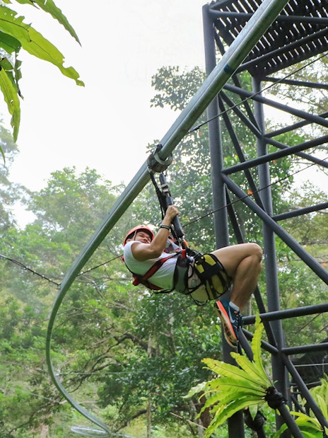 Ziplining through lush forest at Hanuman World, Thailand.