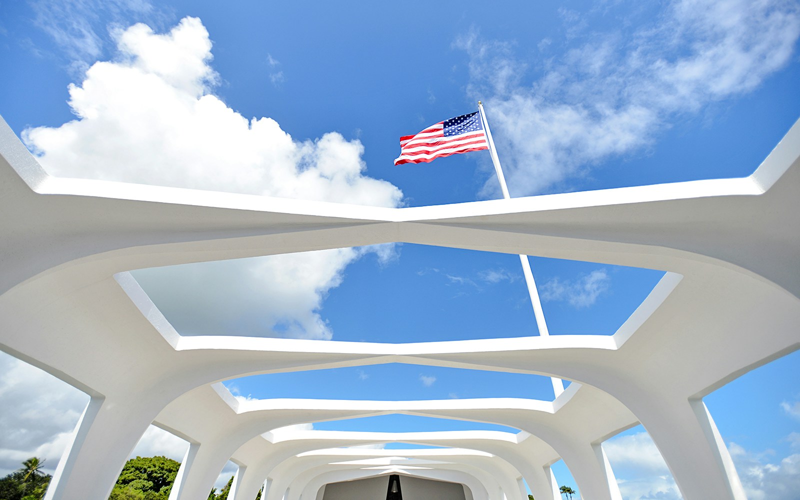 American flag flying over the USS Arizona Memorial in Pearl Harbor, Hawaii.