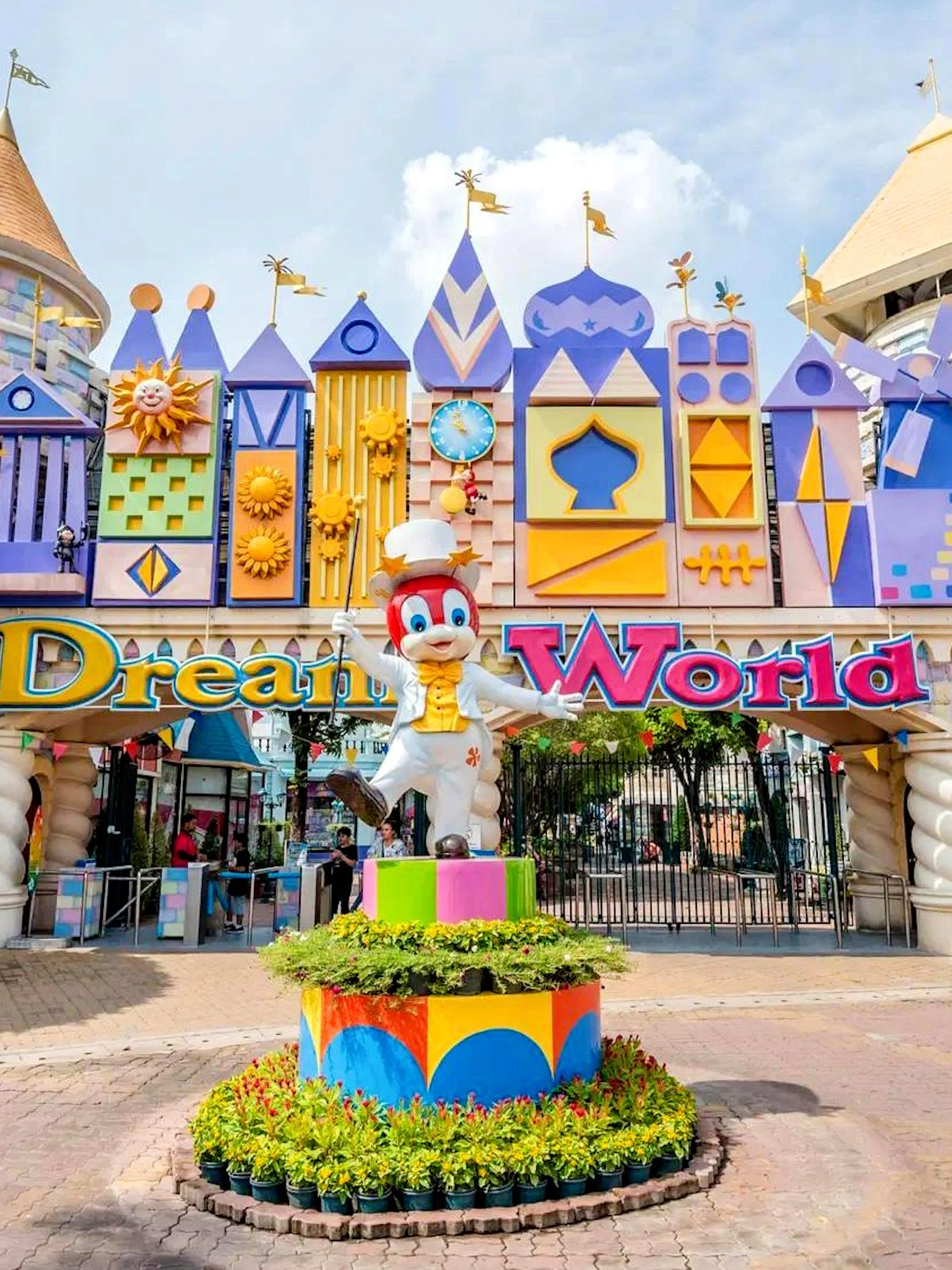 Dream World theme park entrance with colorful facades, mascot statue, and "Dream World" sign.