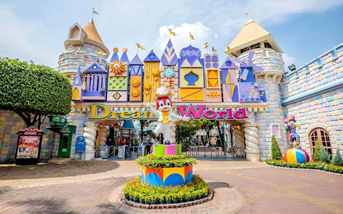 Dream World theme park entrance with colorful facades, mascot statue, and "Dream World" sign.