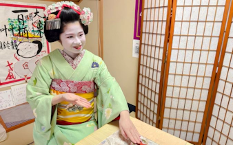 Maiko in traditional attire performing a tea ceremony in Kyoto.