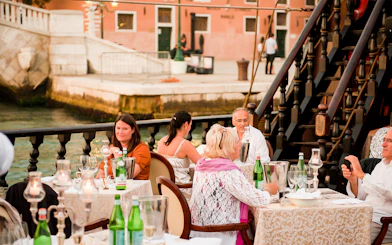 Guests dining on a galleon during a dinner cruise in Venice.