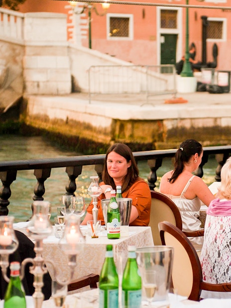 Guests dining on a galleon during a dinner cruise in Venice.