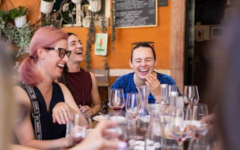 Group enjoying wine and laughter at a Verona café during the Romeo & Juliet food tour.