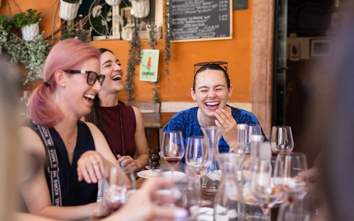 Group enjoying wine and laughter at a Verona café during the Romeo & Juliet food tour.