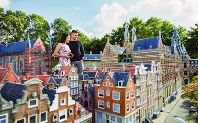 Visitors exploring miniature Dutch buildings at Madurodam park.