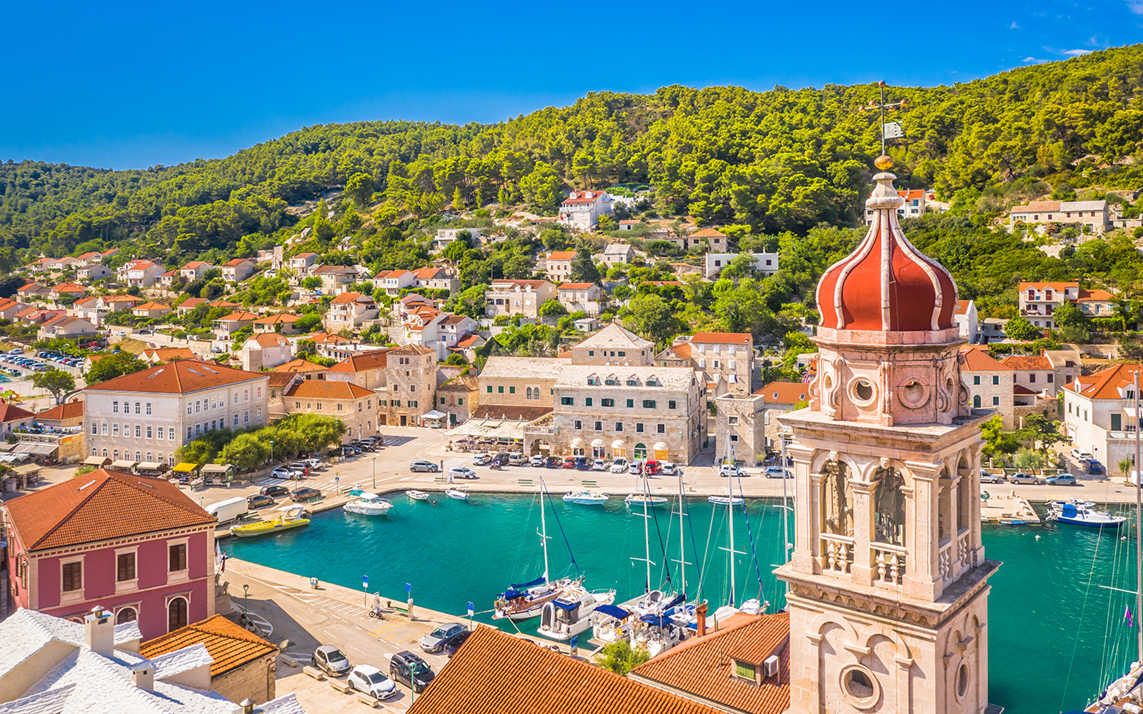 Pučišća harbor with boats and hillside houses on Brac Island, Croatia.