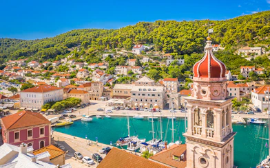 Pučišća harbor with boats and hillside houses on Brac Island, Croatia.