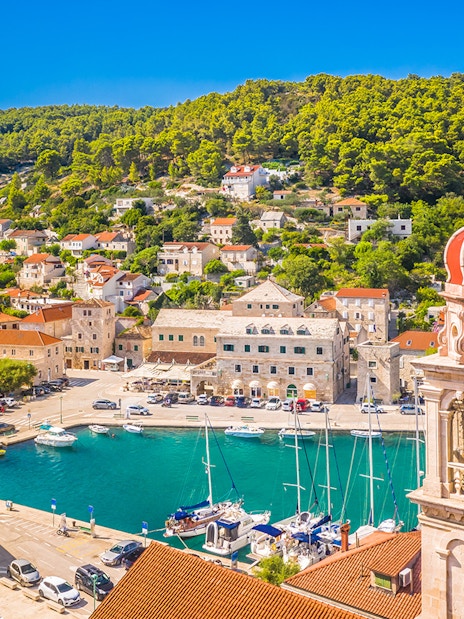 Pučišća harbor with boats and hillside houses on Brac Island, Croatia.