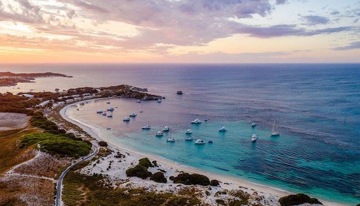 Boats anchored in a bay at sunset on Rottnest Island, Australia.