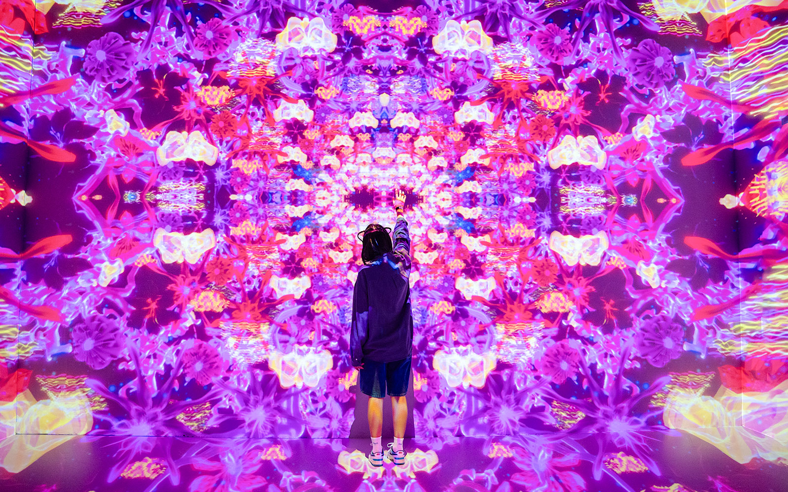 Visitor interacting with vibrant digital art at House of Hype, Dubai.