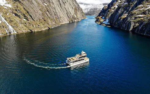 Aerial view of a boat cruising through Trollfjord, surrounded by steep cliffs, Lofoten.