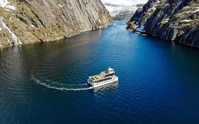 Aerial view of a boat cruising through Trollfjord, surrounded by steep cliffs, Lofoten.