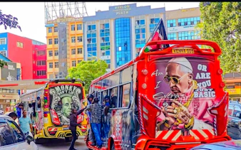 Colorful matatus with street art in Nairobi city center during guided walking tour.