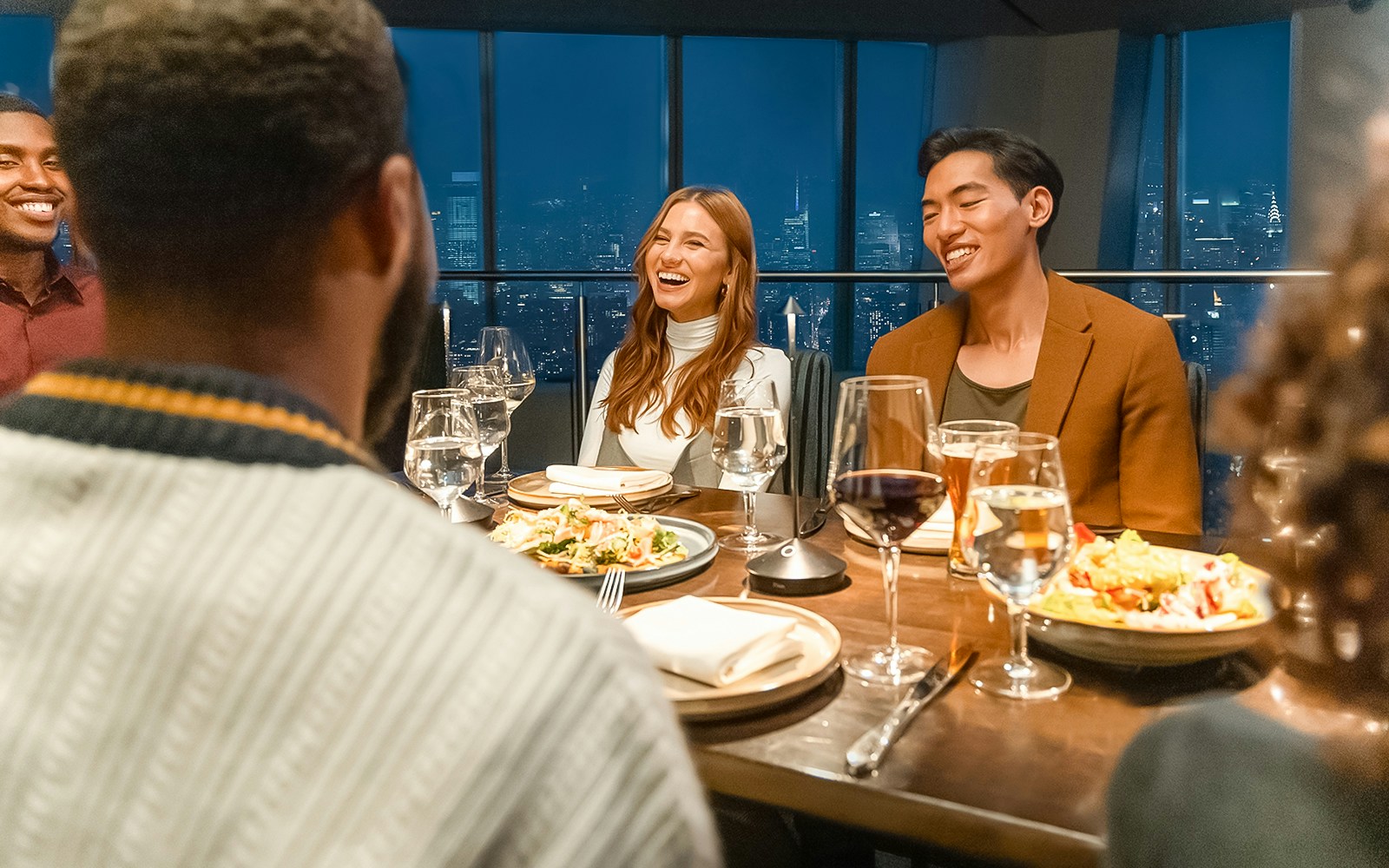 Dinner gathering at One World Observatory with city skyline view.