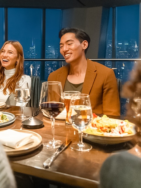 Dinner gathering at One World Observatory with city skyline view.