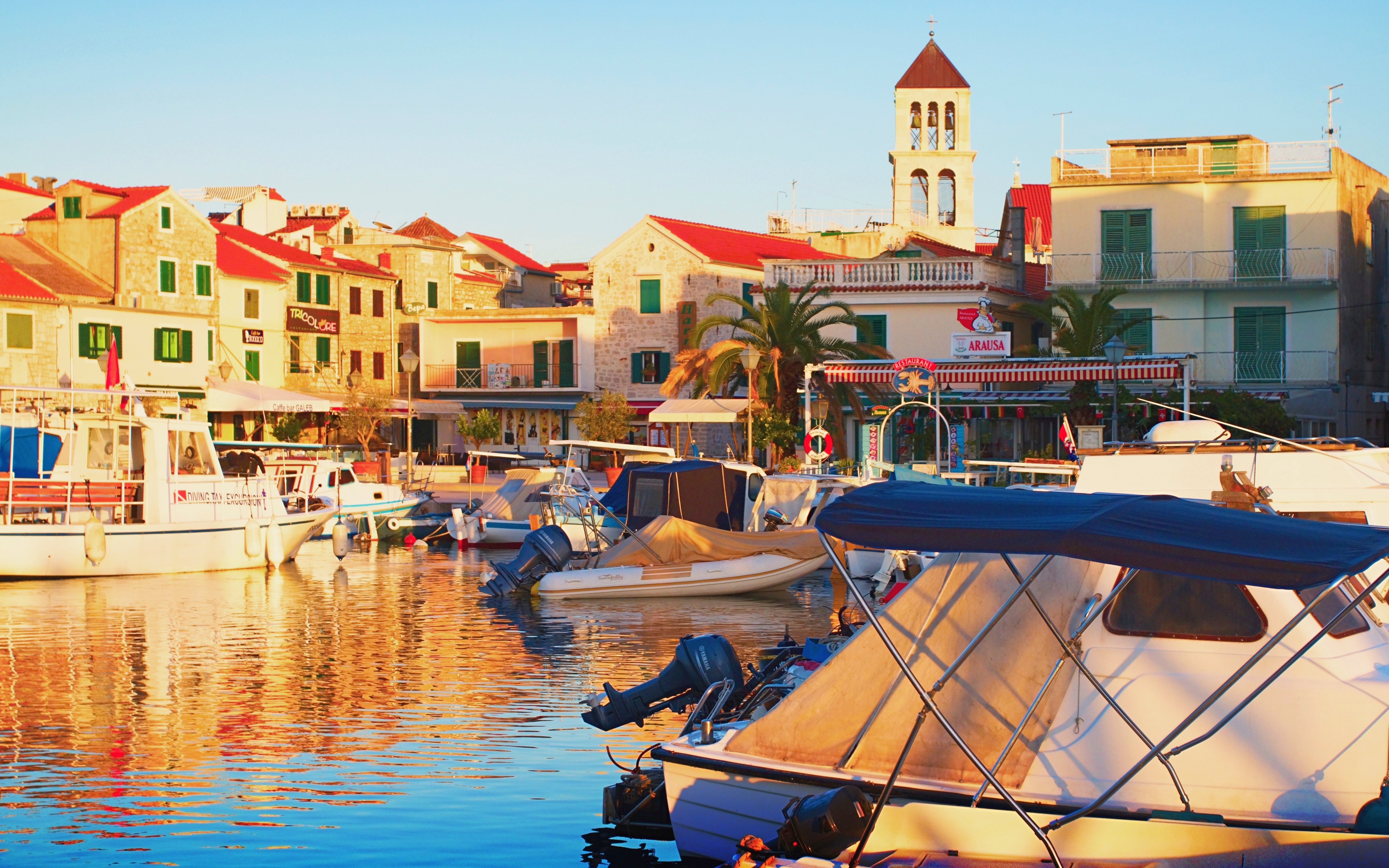 Boats docked at the port in Vodice, central Dalmatia, Croatia, with historic buildings in the background.