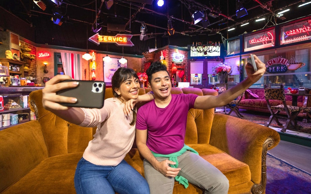 Tourists taking a selfie on the Friends set at Warner Bros. Studio.