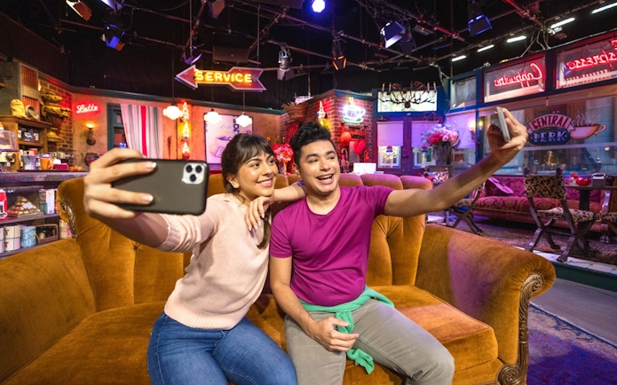 Tourists taking a selfie on the Friends set at Warner Bros. Studio.