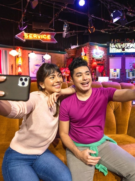 Tourists taking a selfie on the Friends set at Warner Bros. Studio.