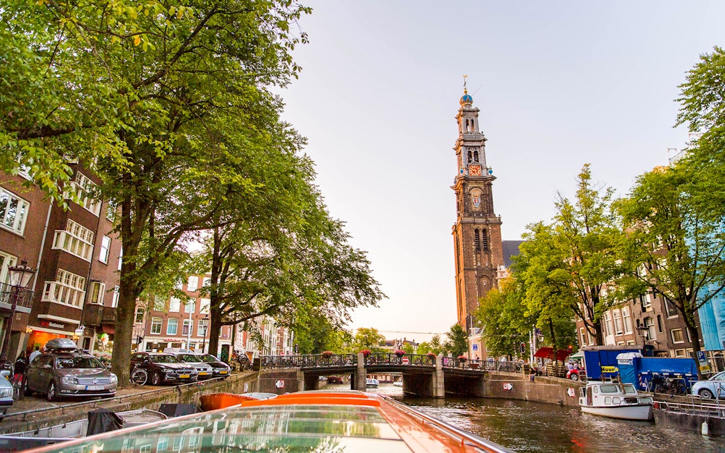 Amsterdam canal view with Westerkerk tower during a canal cruise.