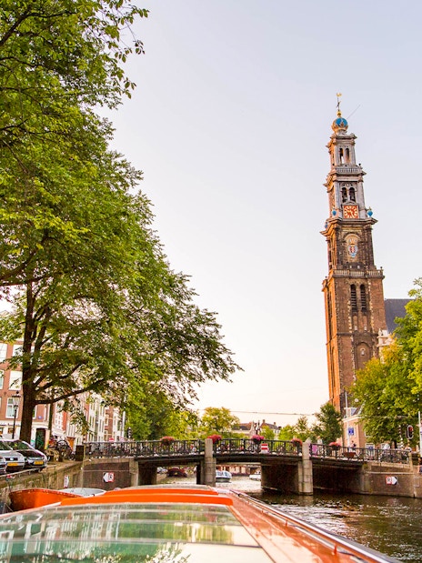 Amsterdam canal view with Westerkerk tower during a canal cruise.