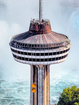 Skylon Tower observation deck with yellow elevator overlooking Niagara Falls.