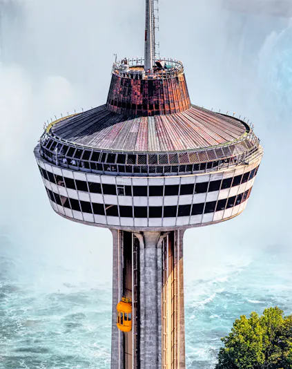 Skylon Tower observation deck with yellow elevator overlooking Niagara Falls.