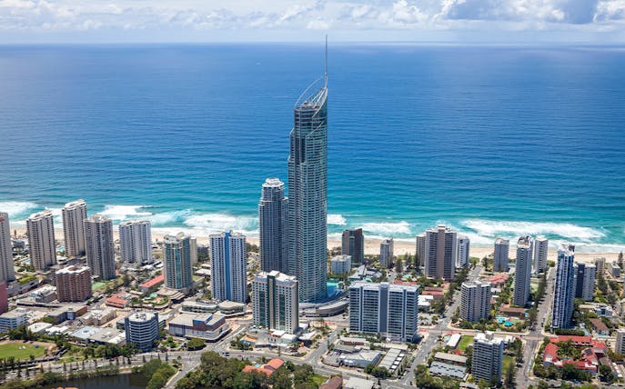 Aerial view of Gold Coast skyline with SkyPoint Observation Deck towering above the city and ocean.