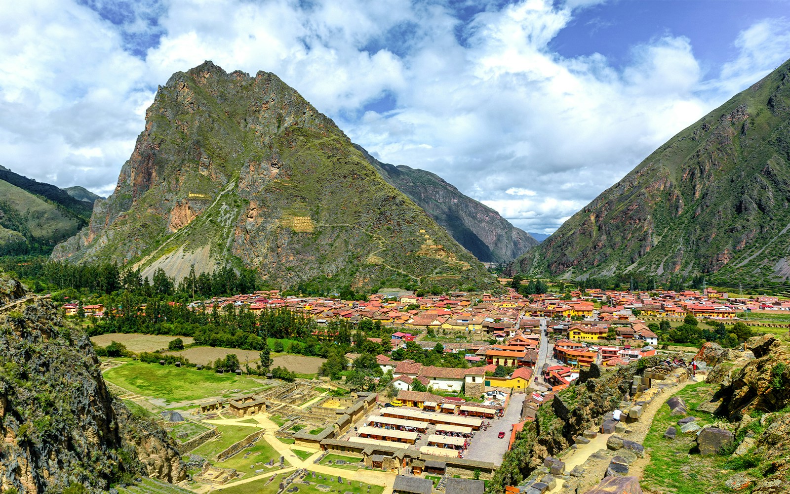 Ollantaytambo village nestled in the Sacred Valley with surrounding mountains, Cusco, Peru.