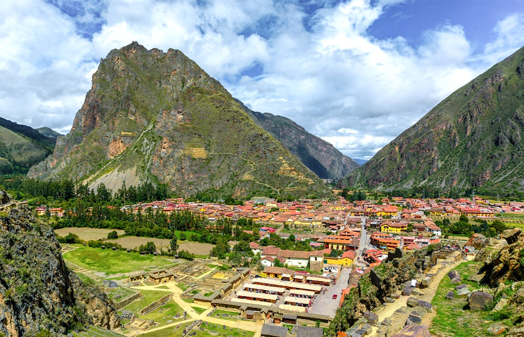 Ollantaytambo village nestled in the Sacred Valley with surrounding mountains, Cusco, Peru.