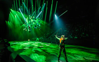 Performer with bow on stage during Hunger Games West End show.