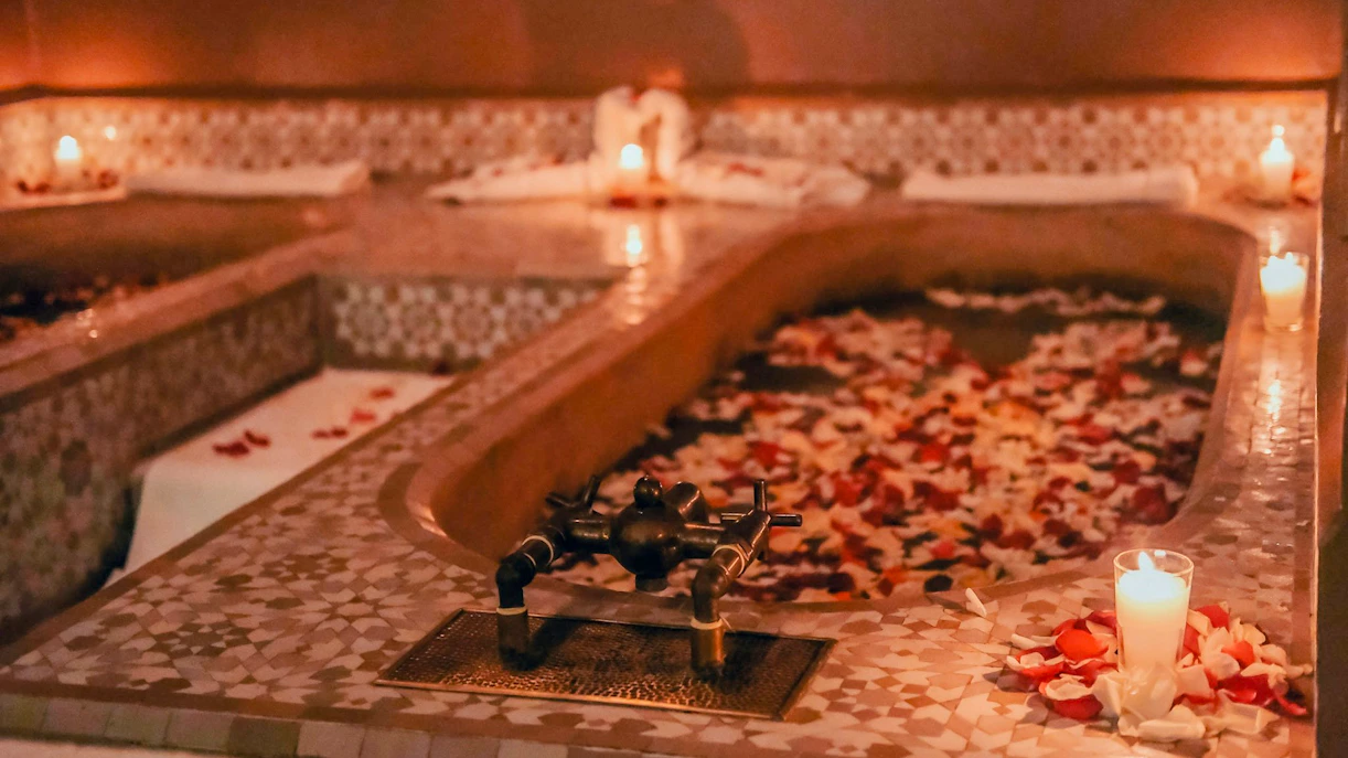 Luxury steam hammam with rose petals and candles in spa setting.
