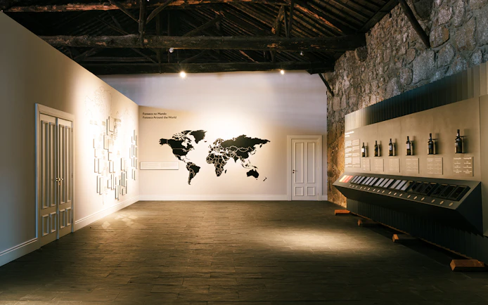 Fonseca port wine cellar interior with world map display and wine bottles.