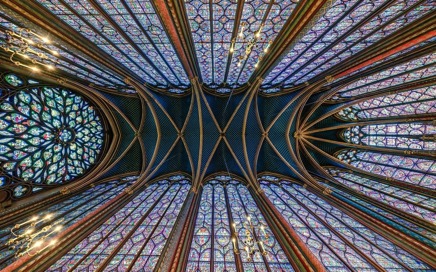 Stained glass windows and vaulted ceiling of Sainte-Chapelle interior in Paris.