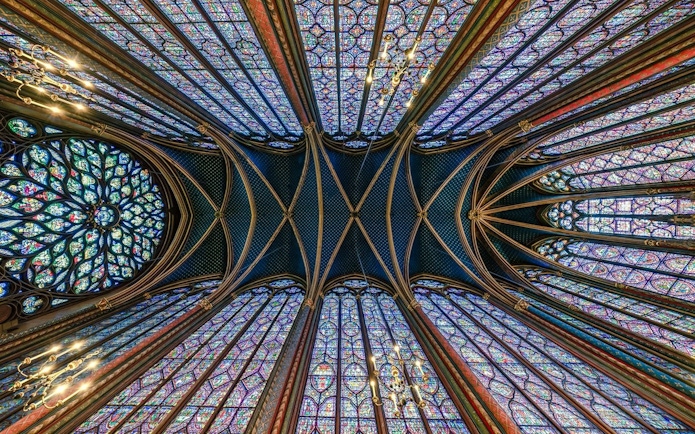 Stained glass windows and vaulted ceiling of Sainte-Chapelle interior in Paris.