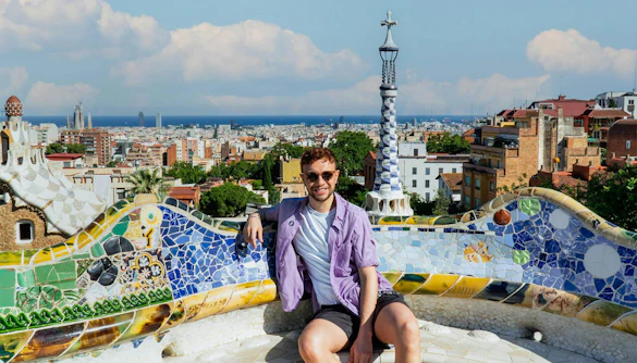 Man taking picture at iconic spot in Park Guell, Barcelona