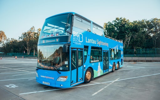 Lantau Island sightseeing bus parked in an empty lot, ready for hop-on hop-off tour.